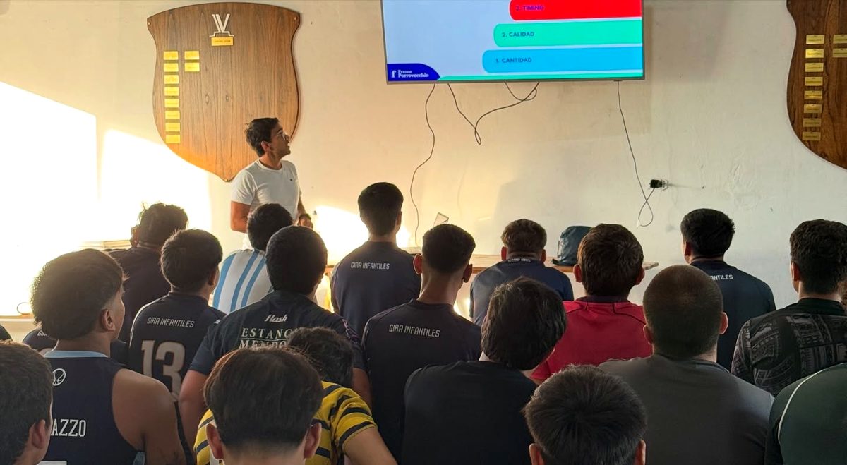 Franco da una charla de nutrición a jugadores en el club, con su diapositiva en la pantalla