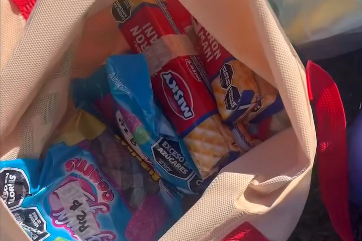 Una bolsa con el intra de un equipo: gomitas, galletitas y turrones, rotulada a mano